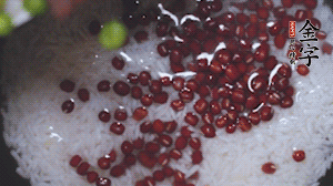 將炒好的食材和大米、紅豆一起放進(jìn)電飯鍋煮。