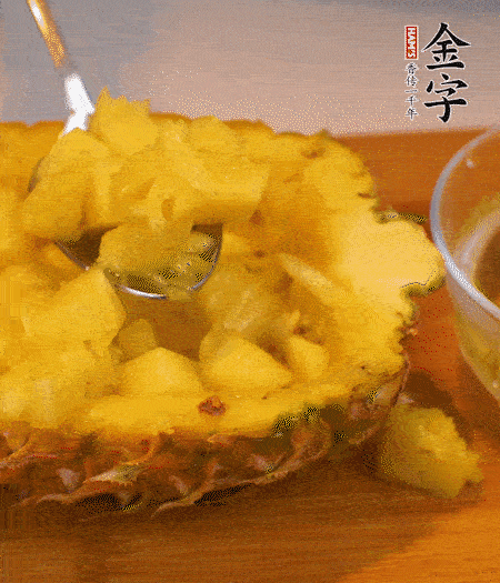 菠蘿對半切開(kāi)，切成小方格，用勺子把菠蘿肉挖出來(lái)。用鹽水稍浸泡。