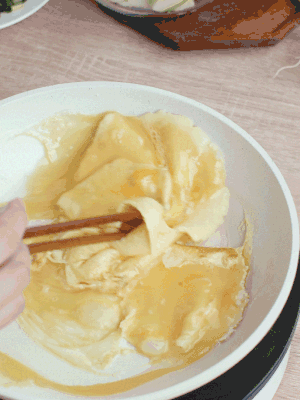 油6成熱時(shí)，下雞蛋液，邊緣凝固時(shí)翻拌成塊狀。